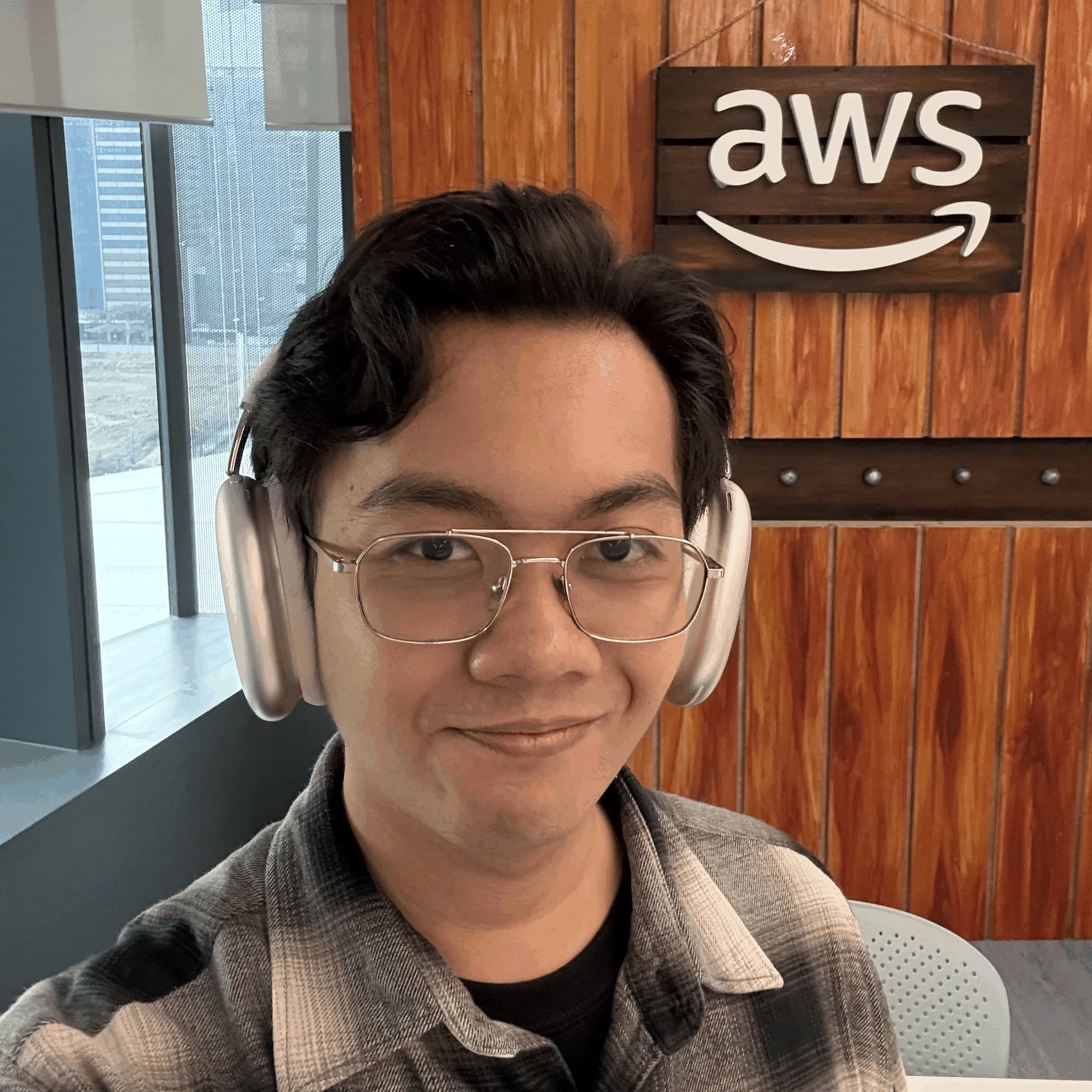 JC Diamante smiling in front of an AWS sign